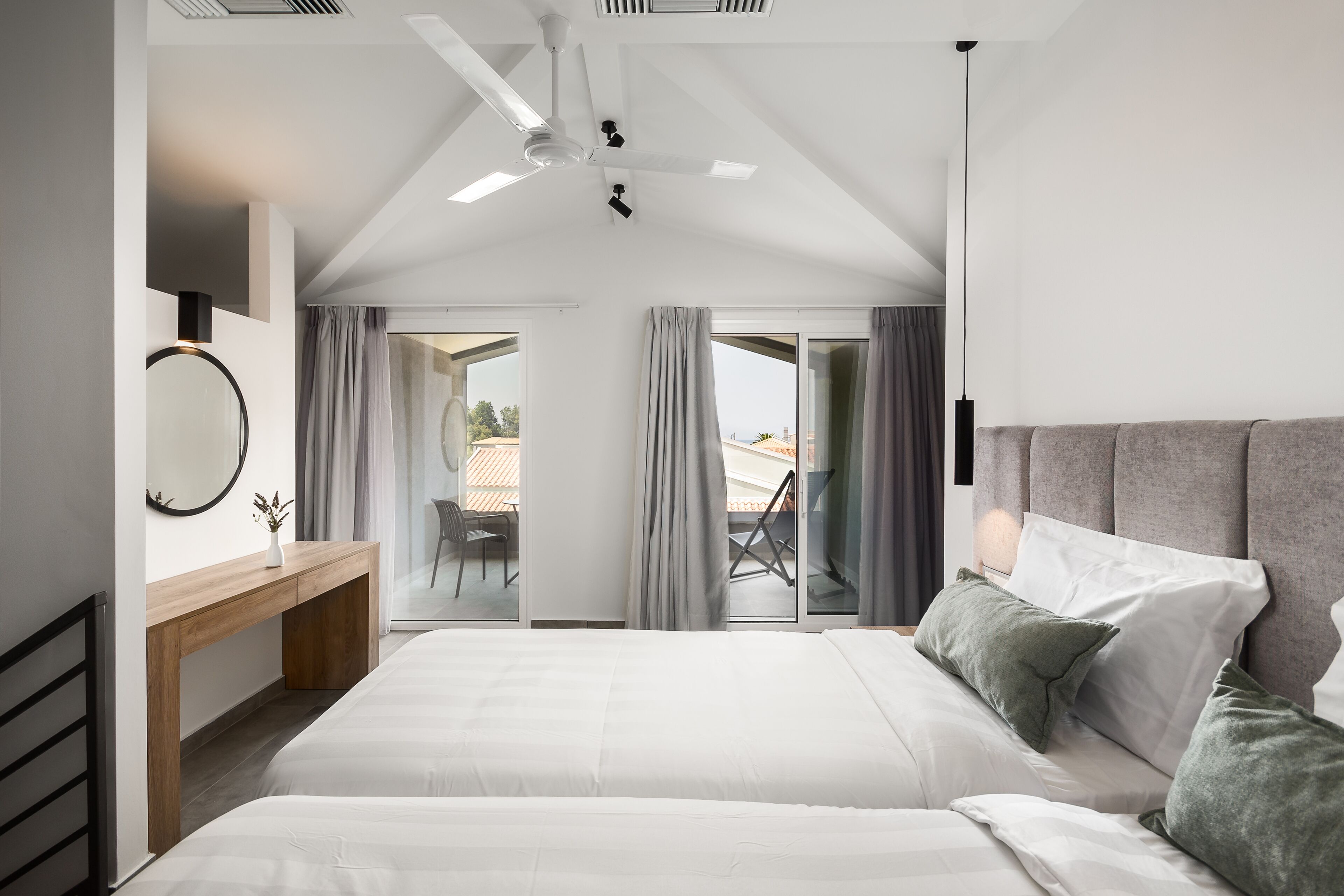 Et moderne hotelværelse med en stor seng, et skrivebord og udsigt til det fri.