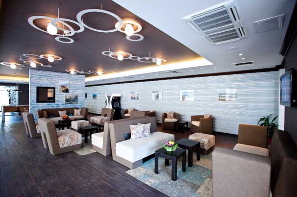 A modern lobby with sofas, tables, and a TV screen. - Hotel Lion Sunny Beach (Sunny Beach)