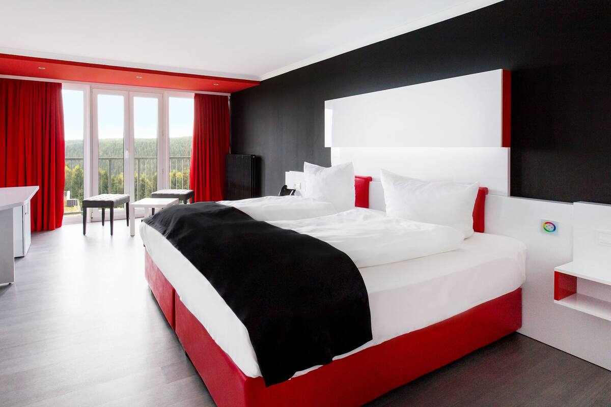 Habitació d'hotel moderna amb un llit gran, un escriptori i una cadira.