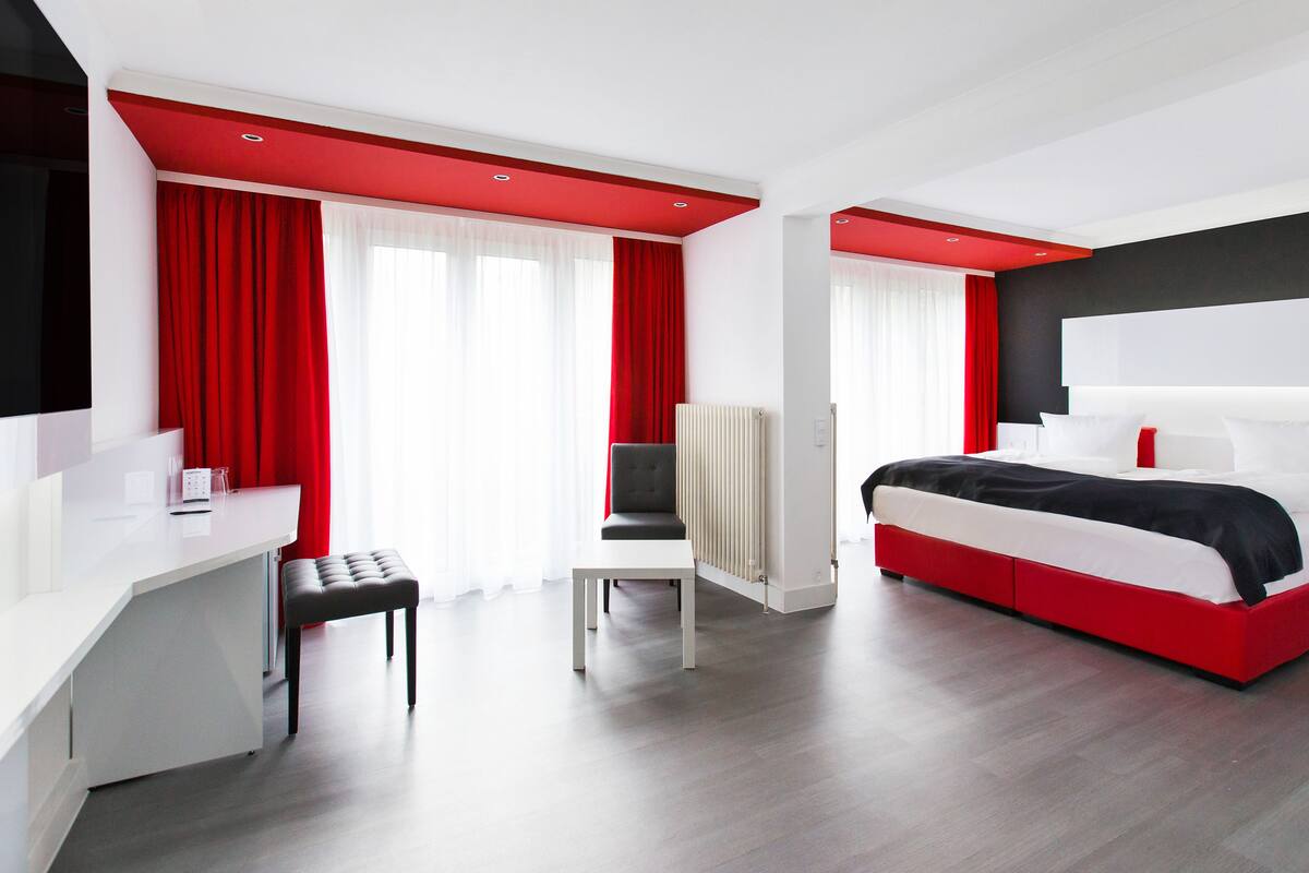 Habitació d'hotel moderna amb llit, escriptori, cadira i radiador.