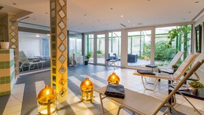 Un vestíbulo de hotel moderno con piso a cuadros, sillones de descanso y vista al patio exterior.