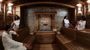 A wooden sauna with stone walls and benches.