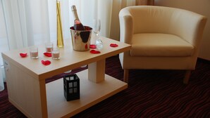 Une chambre d’hôtel avec une table en bois, une bouteille de champagne et un verre.
