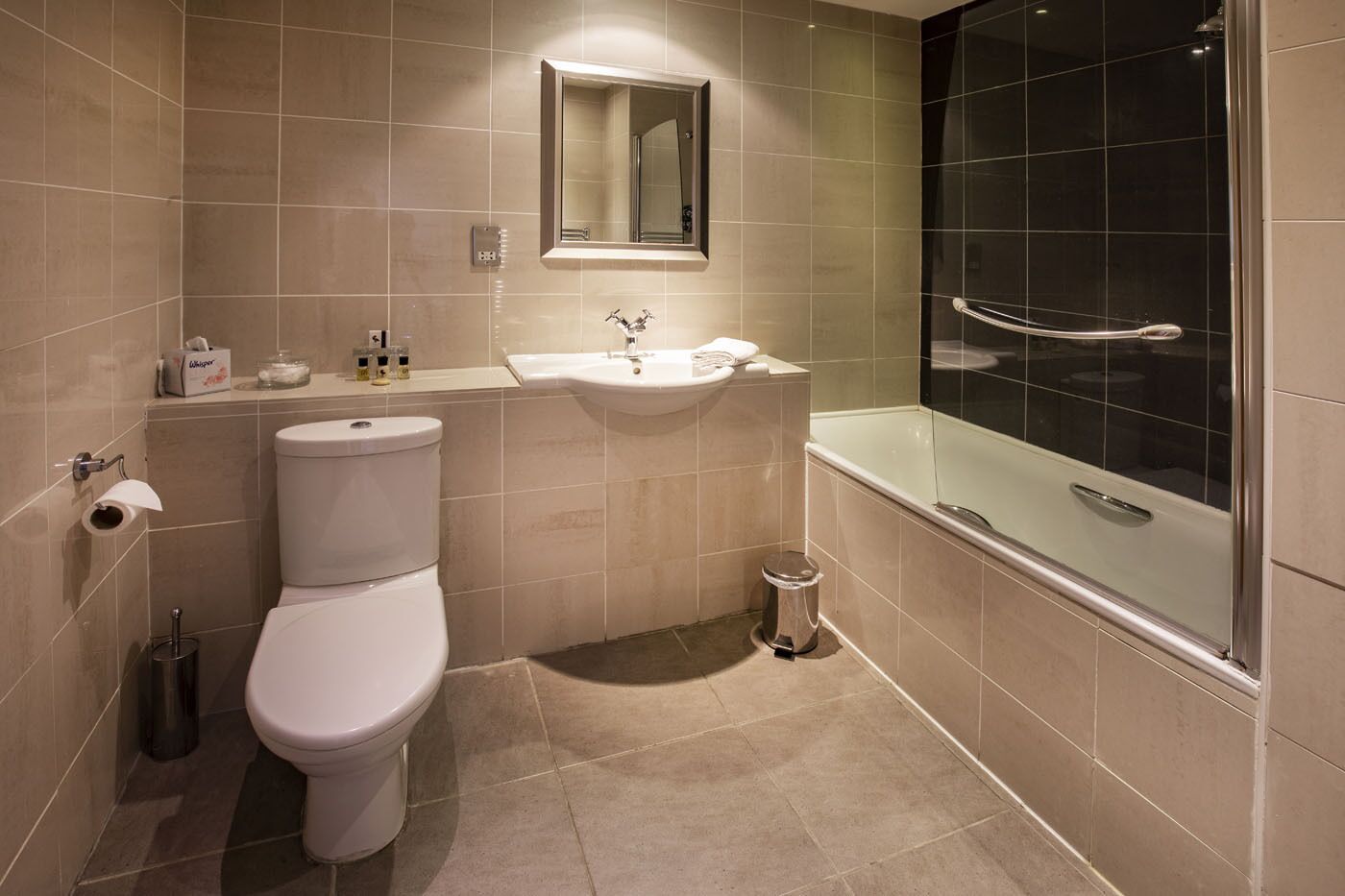 A bathroom with a toilet, sink, and glass-enclosed shower.