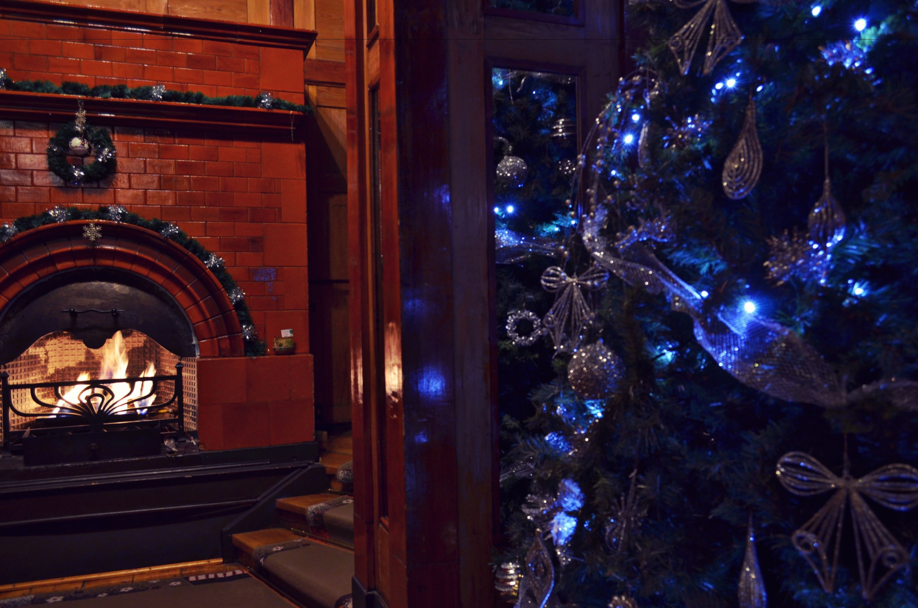 A fireplace with a brick surround and a mantel decorated with a wreath.