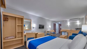 A hotel room with a bed, a desk, a chair, a wardrobe, and a television. - City Express by Marriott Puebla Angelopolis (Puebla)