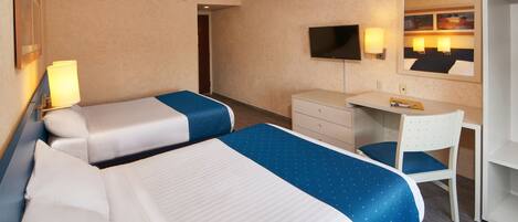 A hotel room with two beds, a desk, a chair, a television, and a mirror.