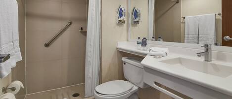 A modern bathroom with a shower, toilet, and sink.