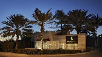 A modern building with a sign reading "Four Seasons Resort and Residences".
