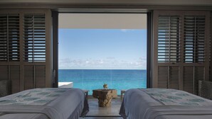 A room with two beds facing a large window overlooking the sea. - Four Seasons Resort and Residences Anguilla (West End Village)