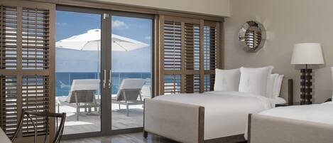A hotel room with a balcony, a bed, a chair, and a table.