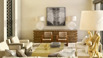 Una sala de estar moderna con un sofá, dos sillones, una mesa de centro y una chimenea.