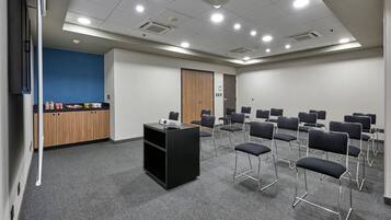 A conference room with a black podium, multiple chairs, and a blue accent wall.