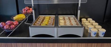A buffet with various food items and containers.