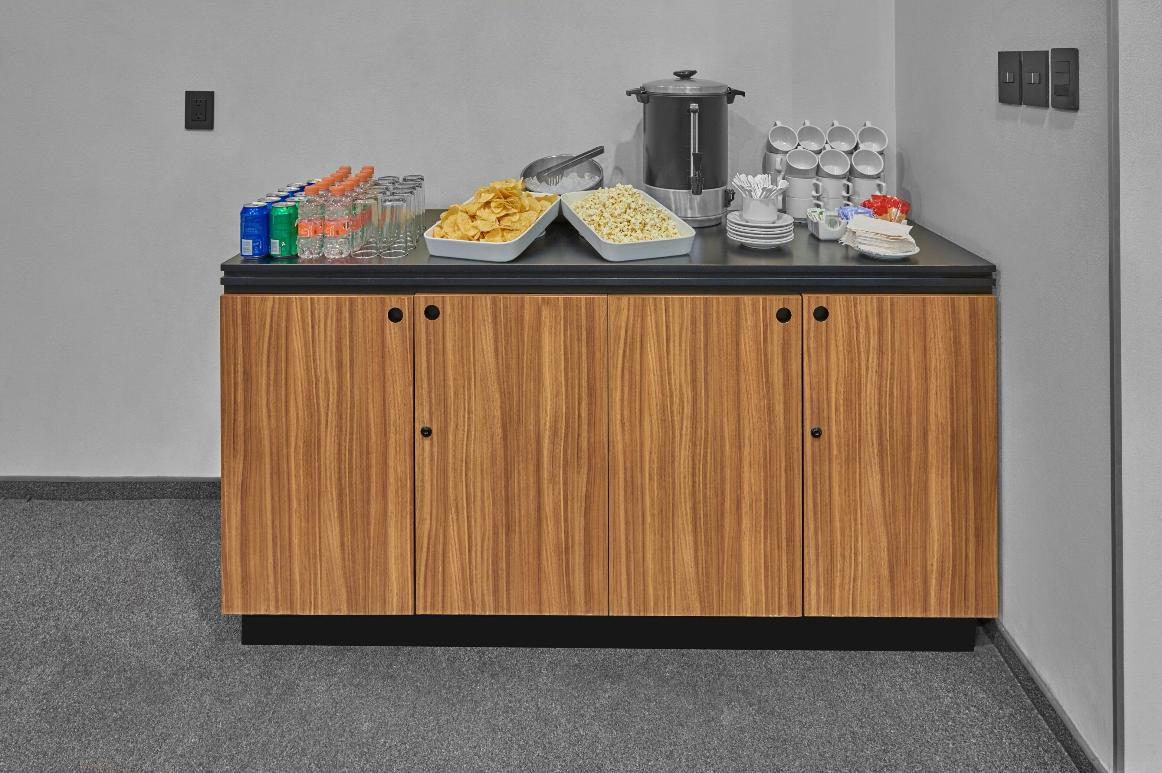 A buffet setup with snacks, drinks, and a coffee station.