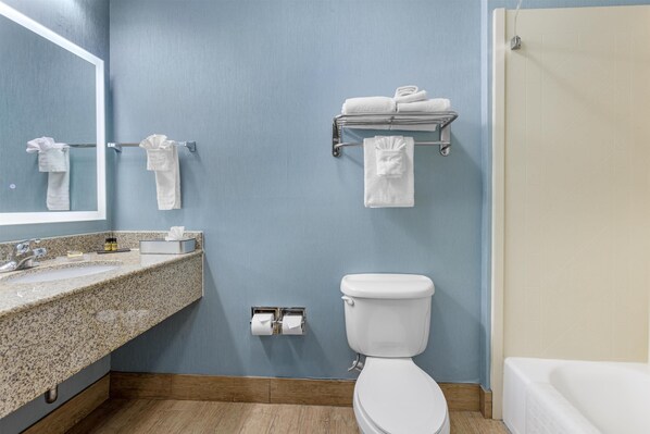 A bathroom with a sink, toilet, and bathtub.
