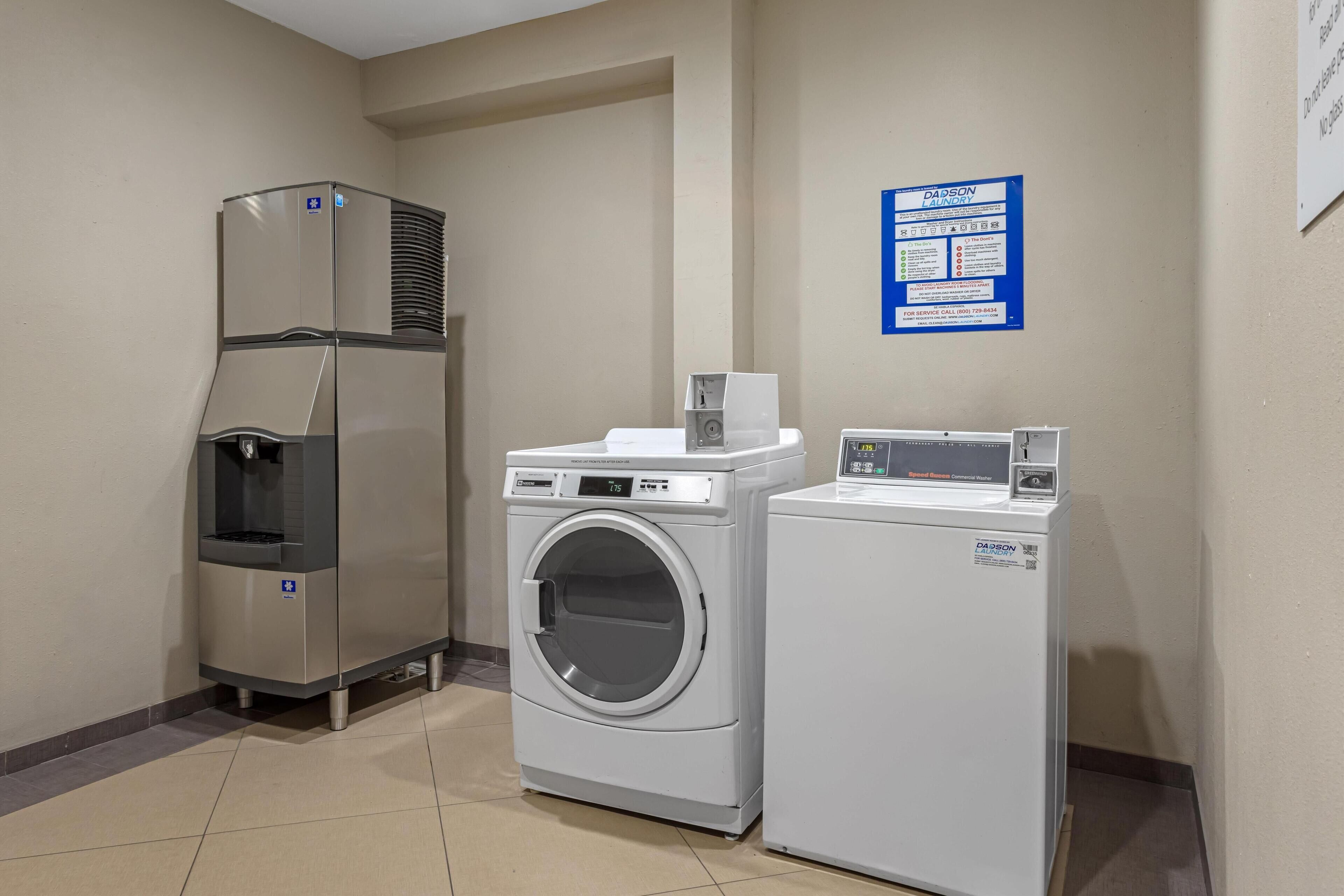 A laundry area with a refrigerator, a washing machine, and a dryer.