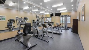 Un gimnasio con diverso equipo de ejercicio, espejos y una cinta de correr T80.