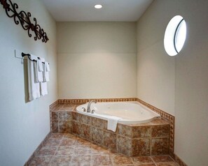 A bathroom with a freestanding bathtub, a wall-mounted towel rack, and a round mirror.