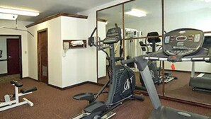Un gimnasio con equipo de ejercicio, un espejo y una puerta.