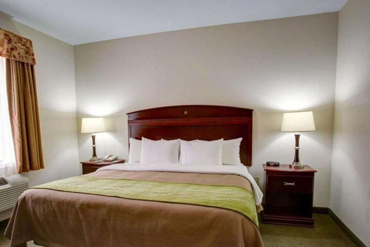 Escritorio, cortinas opacas, tabla de planchar con plancha
