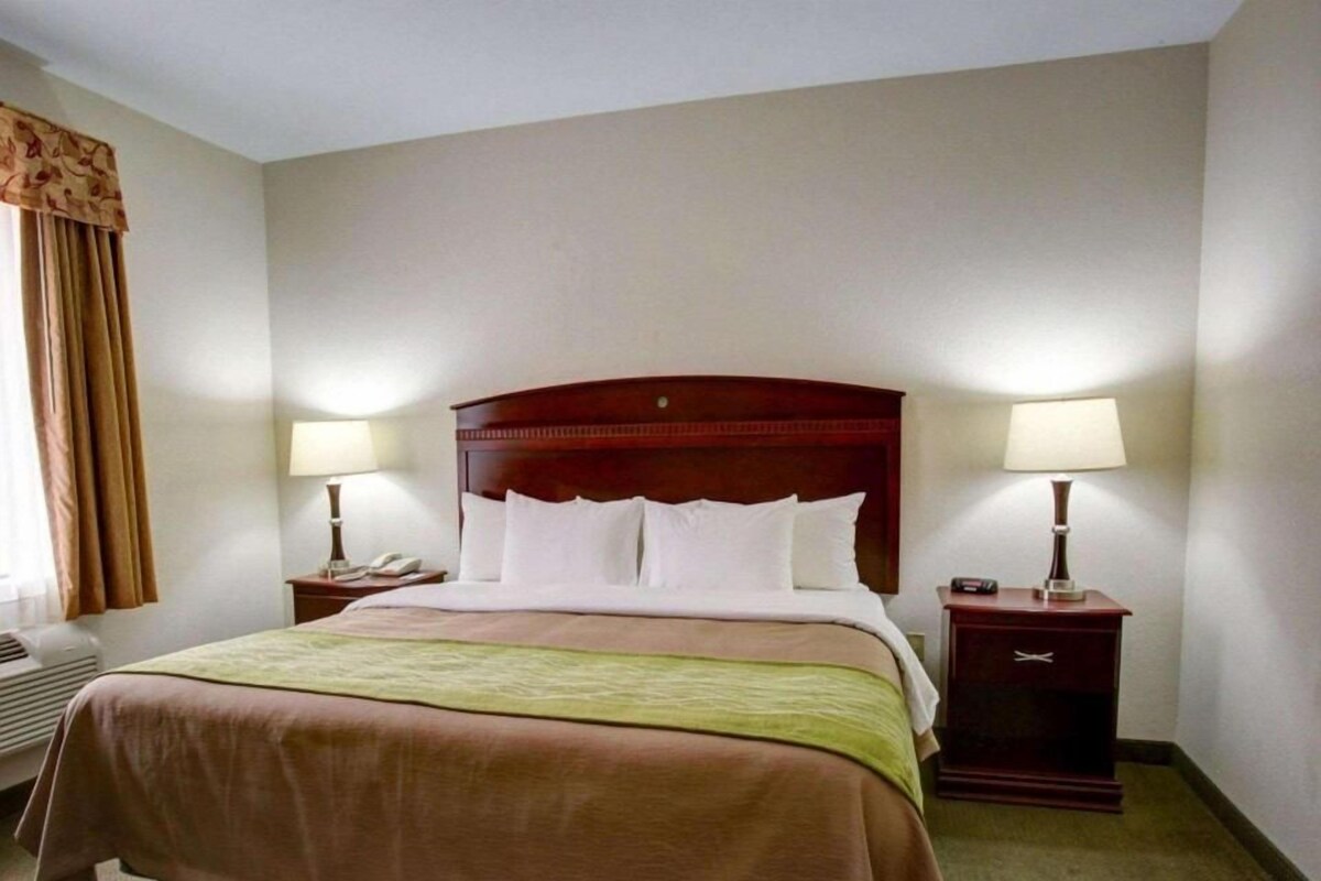 Escritorio, cortinas opacas, tabla de planchar con plancha
