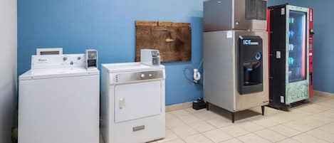 Pesutiloissa on Whirlpool-merkkinen pesukone, Frigidaire-merkkinen kuivausrumpu, jääpalakone ja Coca-Cola-jääkaappi.