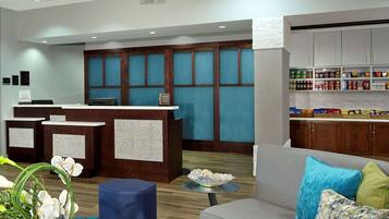 A modern lobby with a reception desk, seating area, and a display of snacks.