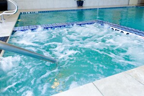 A hot tub with a metal ladder and a tiled edge. - Holiday Inn Houston Webster by IHG (Webster)