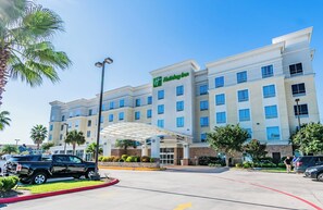 A Holiday Inn hotel with a modern design, featuring a covered entrance and multiple floors. - Holiday Inn Houston Webster by IHG (Webster)