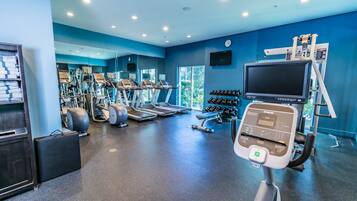 A gym with treadmills, weights, and exercise equipment.