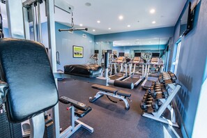 A gym with exercise equipment, benches, and treadmills. - Holiday Inn Houston Webster by IHG (Webster)