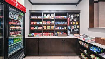 A refrigerated beverage display and shelves stocked with snacks and packaged goods.