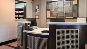 Zona de recepción de hotel con mostrador, computadora y exhibición de servicios.