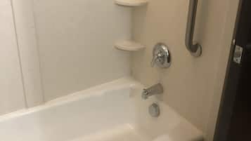 Une salle de bain standard équipée d’une baignoire, d’une barre d’appui et d’un porte-serviettes.