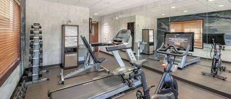 A gym with treadmills, an elliptical, and a stationary bike.