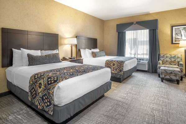 A hotel room with two beds, a chair, a desk, and a window with curtains. - Best Western Plus Ponderay Mountain Lodge (Ponderay)
