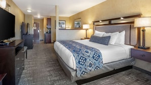 A hotel room with a large bed, a desk, a TV, and a bathroom visible in the background. - Best Western Plus Ponderay Mountain Lodge (Ponderay)