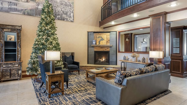 A spacious lobby with a large Christmas tree, a fireplace, and a high ceiling with a balcony. - Best Western Plus Ponderay Mountain Lodge (Ponderay)