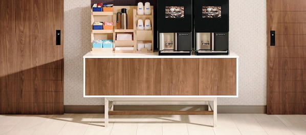 Una encimera de madera con compartimentos de almacenamiento y dos máquinas de café.