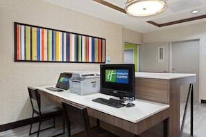 Mostrador de recepción de hotel con computadora, impresora y sillas.