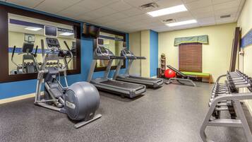 A gym with treadmills, an elliptical, and free weights.
