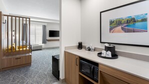 A hotel room with a bed, a TV, a coffee machine, and a framed picture on the wall. - Hampton Inn & Suites Chicago Deer Park (Barrington)
