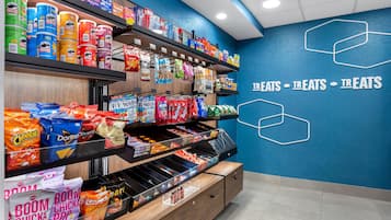 Pasillo con diversas papas fritas, aperitivos y alimentos envasados.