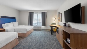 A hotel room with two beds, a desk, a flat-screen TV, a lamp, and a window with curtains. - Hampton Inn & Suites Chicago Deer Park (Barrington)