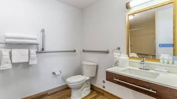 A modern bathroom with a white toilet, a sink with a mirror, and a towel rack.