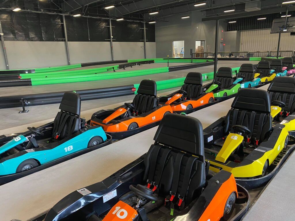 A go-kart track with multiple go-karts lined up in rows.