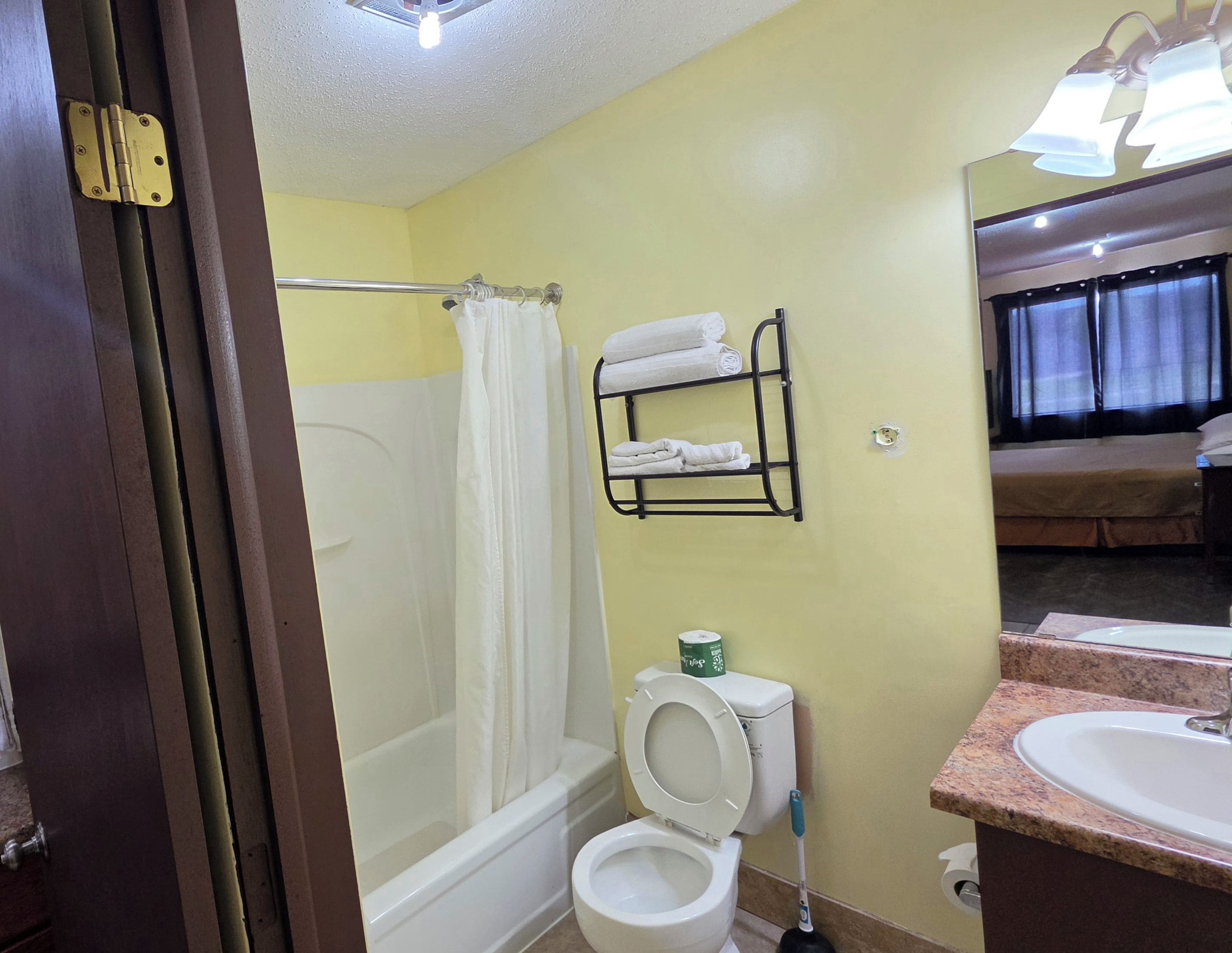A bathroom with a bathtub, toilet, and a sink.