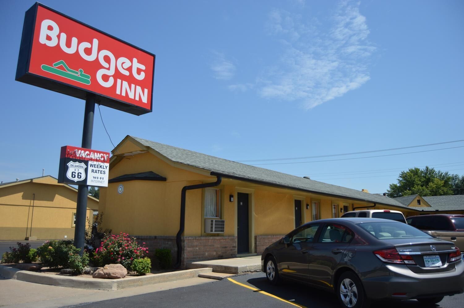 A Budget Inn with a sign indicating weekly rates and Wi-Fi internet.