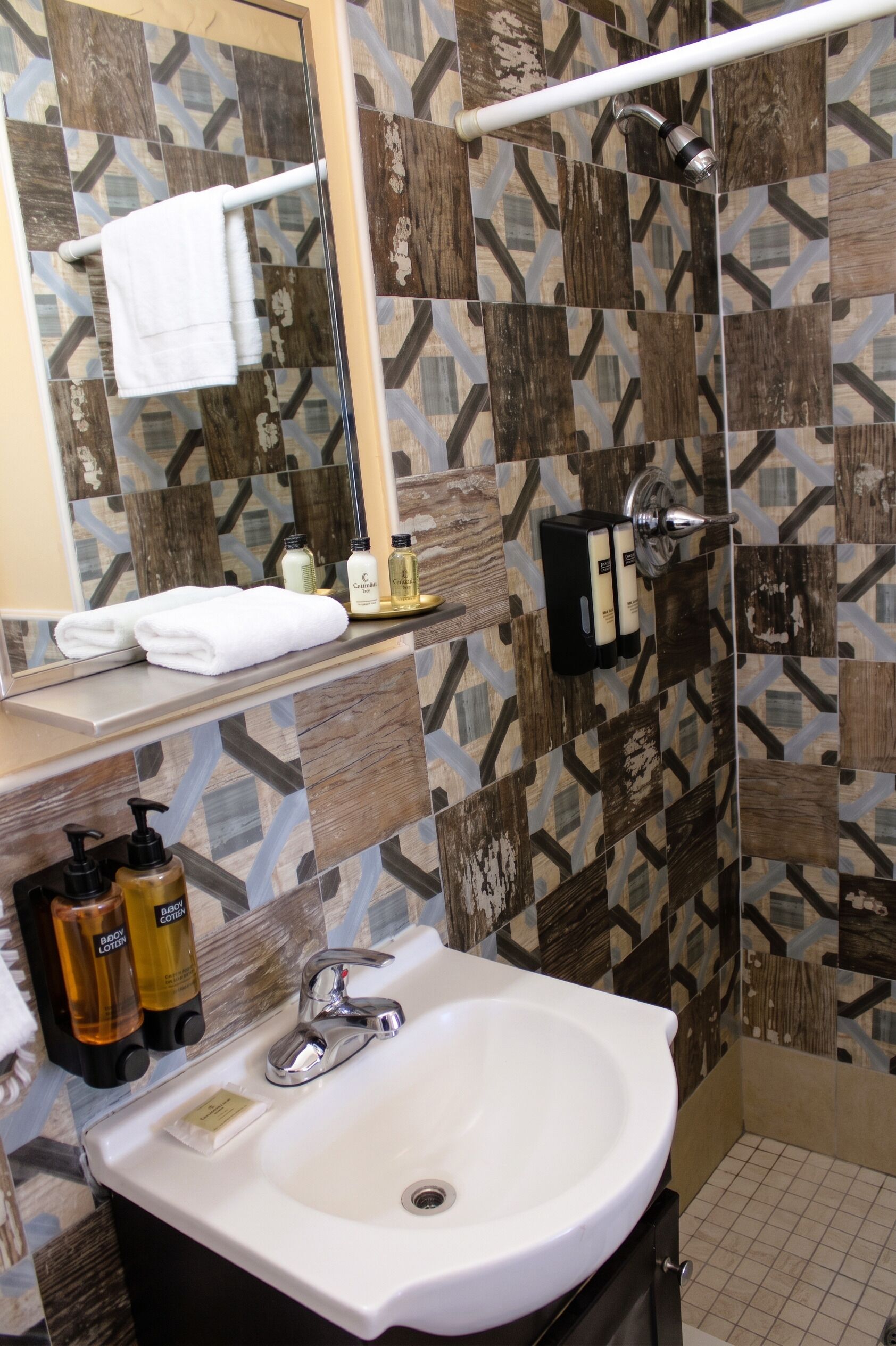 A bathroom with a white sink, a mirror, a towel rack, and a shower.